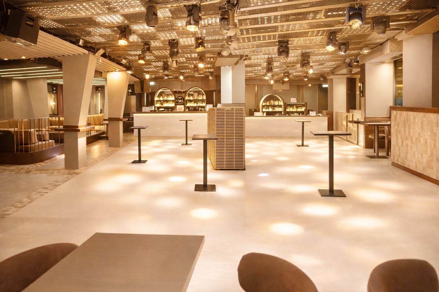 Grosser Saal mit Stehtischen und beleuchteter Decke