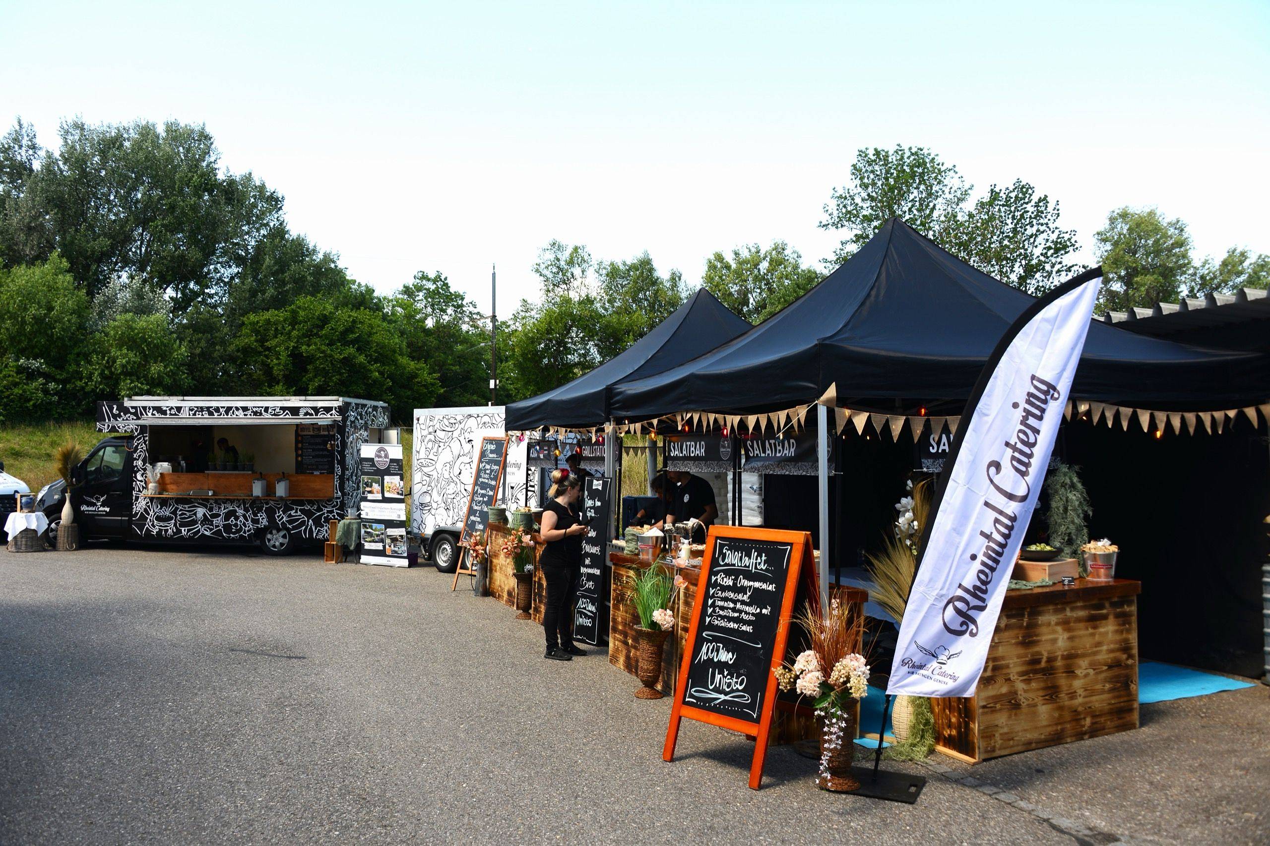 Aufbau von Rheintal Catering mit Foodtruck, Pavillons und Buffetstation im Freien