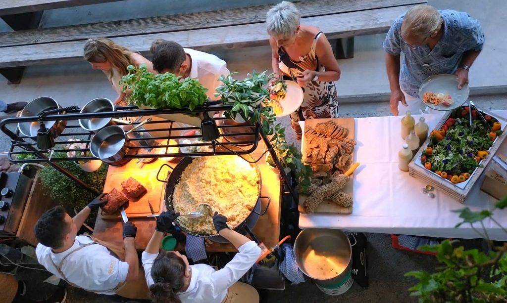 Live Cooking von SKEMA Catering mit Paella-Pfanne und Buffet im Freien
